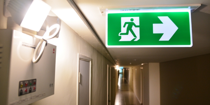 Emergency lights that illuminate a hallway sign